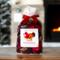 Irish Twins Apple Cinnamon Potpourri bag with red ribbon, against a fireplace and snow-covered pine tree.